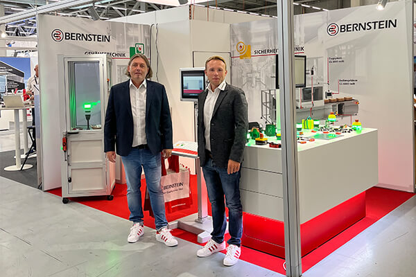 Zwei BERNSTEIN Mitarbeiter vor dem Messestand auf der SINDEX